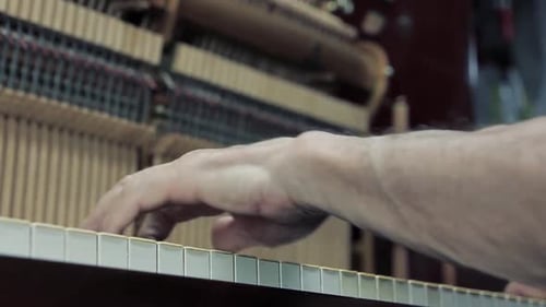 Man Hands playing an Old Piano at Piano Workshop.