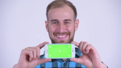 Smiling Man Holds Up Smartphone with Green Screen