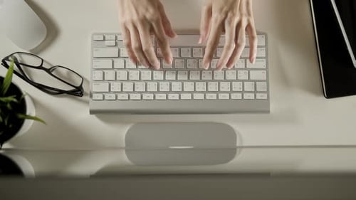 Overhead shot of hands typing on keyboard