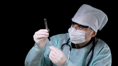 Científico, el médico realiza la Colleción sangre. Transfunde sangre de una jeringa a un tubo de ensayo