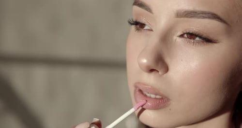 Woman Applying Lip Gloss Close Up