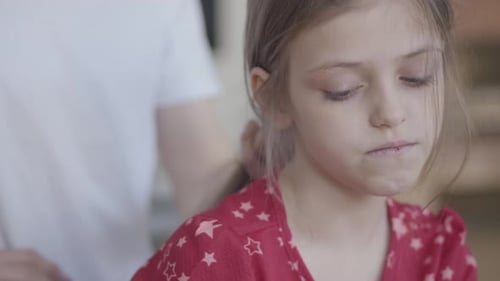 Adult Brushing Child's Fair Hair at Home