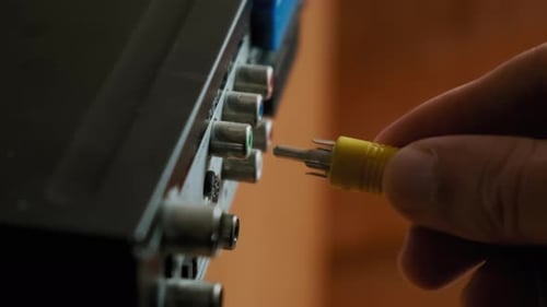 Male Hands PlugIn Rca Cables To Multimedia Electronic Device at Home