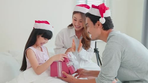 Family Celebrates Christmas with Gifts and Santa Hats