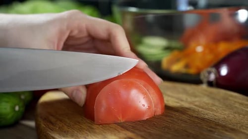 Slicing Red Tomato for Salad Preparation in Kitchen