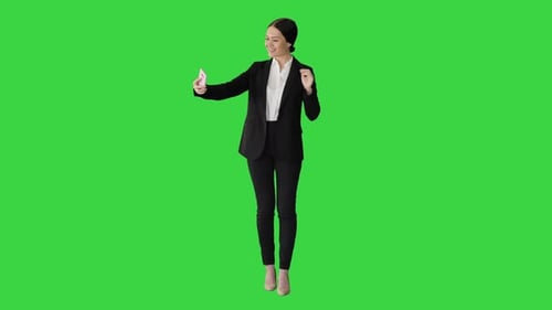 Smiling Businesswoman Taking Selfie on Her Phone on a Green Screen, Chroma Key.