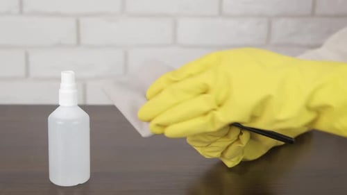 Cleaning a Cell Phone with Yellow Gloves