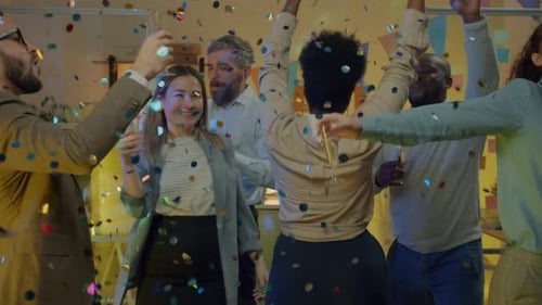 Grupo multiétnico de funcionários dançando em festa de negócios com taças de champanhe, rindo e assistindo