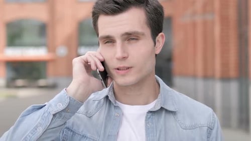 Young Man Talking on Smartphone in Urban Setting