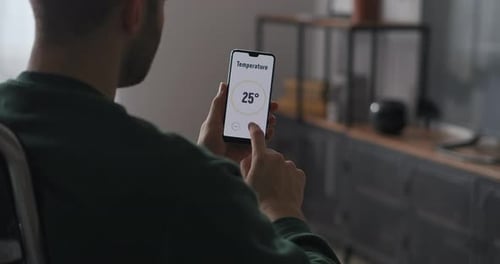 Man Using Smart Home Application on Mobile Phone
