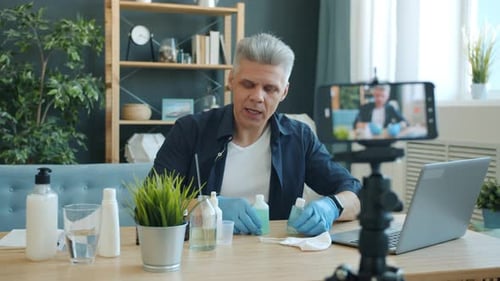 Tutorial de grabación de un vlogger masculino sobre cómo hacer desinfectante para manos con el teléfono inteligente hablando
