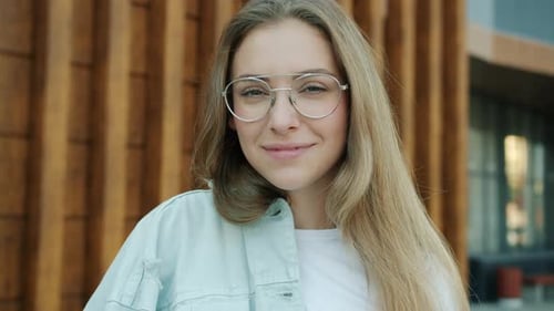 Closeup Portrait of Cute Young Blonde Standing Outdoors in City Smiling Looking at Camera