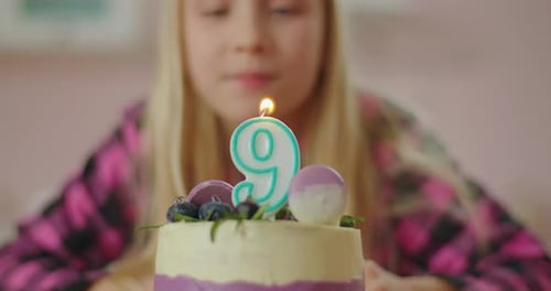 Close Up of Little Girl Blowing Out Candle with Number 9 on Birthday Cake in Slow Motion. Nine Years