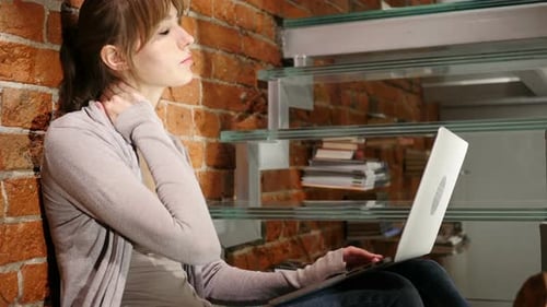 Young Woman Using Laptop on Staircase at Home