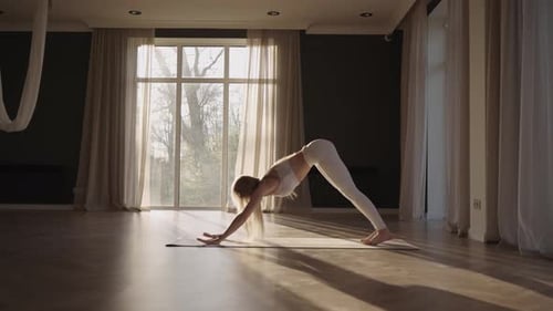 Woman Practicing Yoga in a Sunlit Room