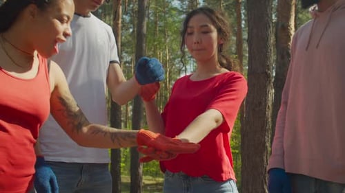 Diverse Group of Young Adults Putting Hands Together