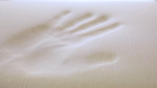 Hand Pushing into Soft Memory Foam Mattress