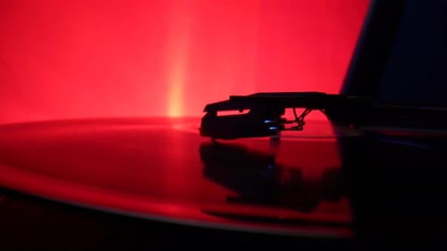 Vinyl Record Spins on an Old Turntable Illuminated By Red Lights