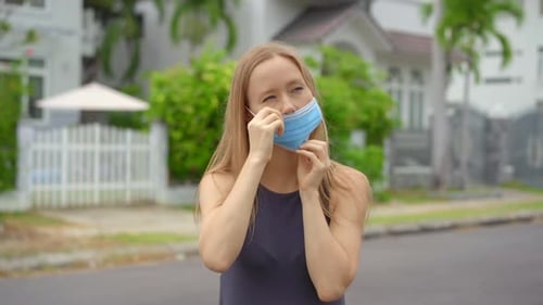 Young Woman Puts on Blue Face Mask