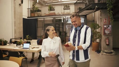 Coworkers Laughing Looking at a Smartphone in Office