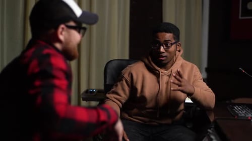 Satisfied AfroAmerican Sound Producer Talking To Talented Musician in Cap at Music Record Studio