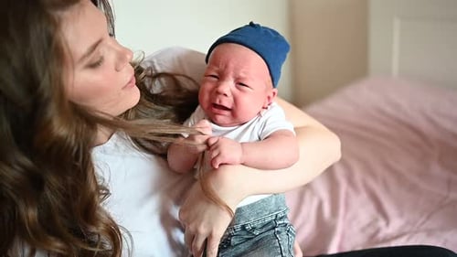Crying Baby Held by Mother at Home