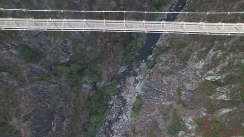 Suspension Bridge with River in Background