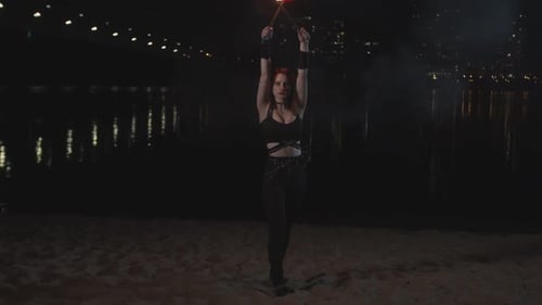 Young Woman Fire Spinning on Beach at Night