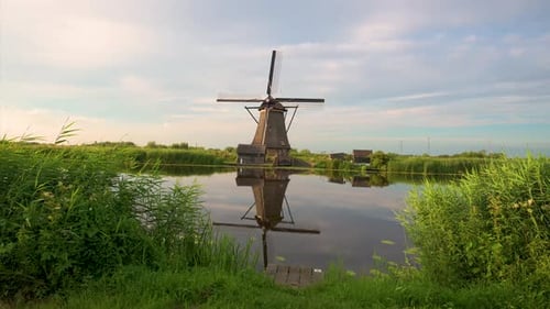 Pan Right of a Wooden Windmill and a River at Sunset in Kinderdijk Netherlands