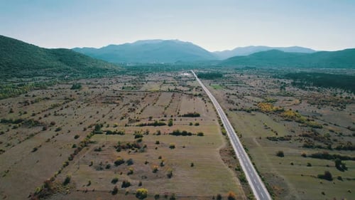 Empty Asphalt Road on the Plateau Between Green Fields Highland Way Aerial View