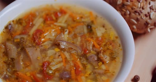 Bowl of Vegetable Soup with a Crusty Roll