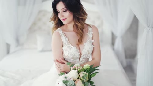 Gorgeous Bride Poses with Flowers in Elegant Room