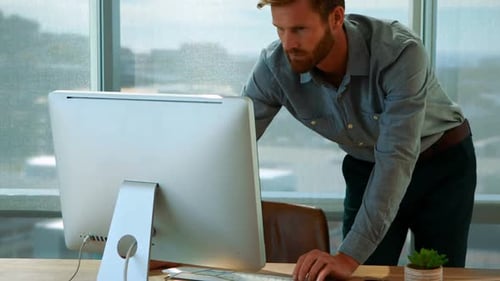 Man Works at Computer in Bright Office