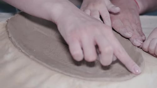 Child and Adult Working with Clay Close Up