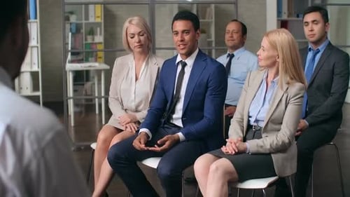 Group of Adults Listening and Clapping at Presentation