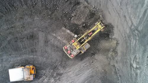 Cable Excavator Loads Overburden From the Body of a Mining Truck.