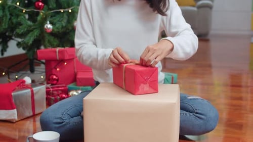 Woman Wrapping Christmas Gifts at Home