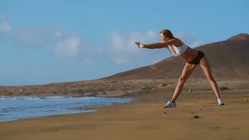 Woman Stretching Legs and Hamstrings Doing Standing Forward Bend Yoga Stretch Pose on Beach