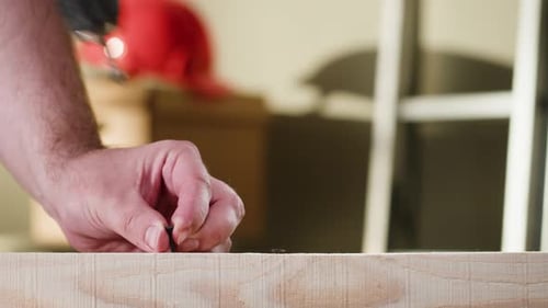 Man Drilling Screw Into Wood With Power Drill