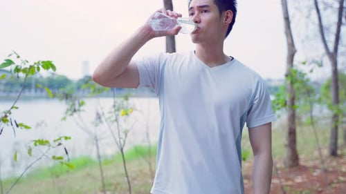 Man Drinking Water After Exercise in Park