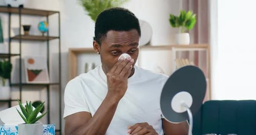 Young Adult Cleans Face with Cotton Pad
