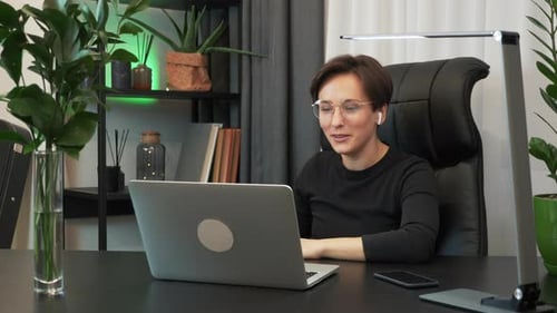 Woman Waving During a Video Call at Desk