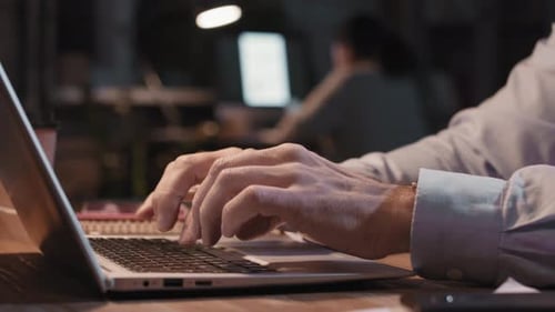 Männliche Hände tippen nachts auf Laptop