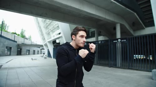Fighter Man Training Boxing Punch on Urban Street. Closeup Man Boxing Outdoor