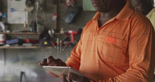 Afrikanischer Mann schaut bei der Arbeit auf Touchpad
