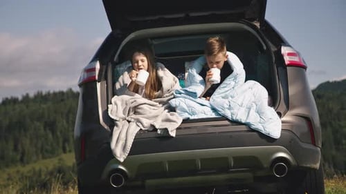 Children Enjoying Drinks in Car Trunk in Nature