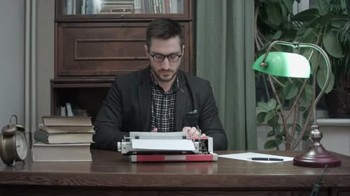Man Typing on Vintage Typewriter at Desk