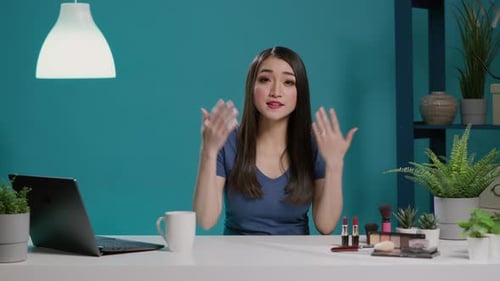 Mujer asiática filmando tutorial de maquillaje para canal en línea