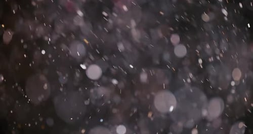 Bokeh Particles Glittering in the Darkness