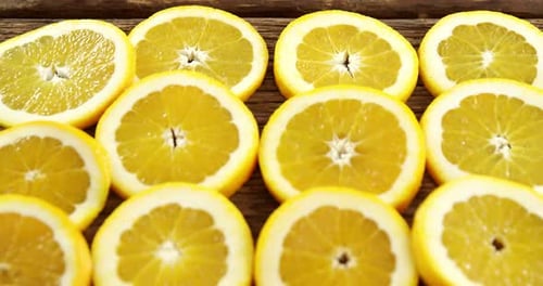 Halved sweet limes arranged on wooden plank